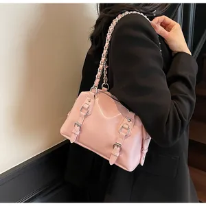 Close-up of light pink glossy PU shoulder bag featuring silver chain and buckle details