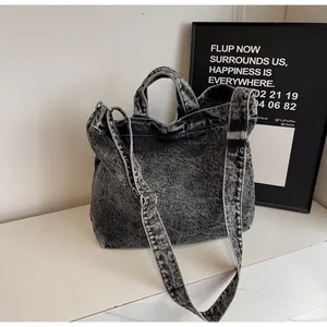 Detail of acid washed black denim tote bag with vintage metal snap button closure