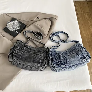 Retro denim dumpling bags in blue and dark grey with adjustable straps and zip pockets