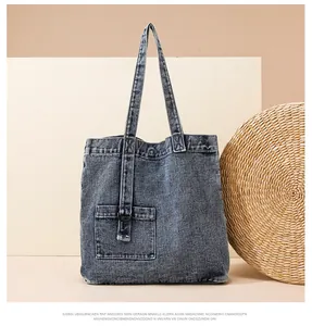 Detail der blauen Denim-Tragetasche mit praktischer Fronttasche und dekorativer D-Ring-Schnalle