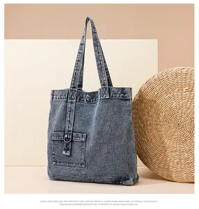 Detail der blauen Denim-Tragetasche mit strukturierter Stofftasche und Metall-D-Ring-Schnalle