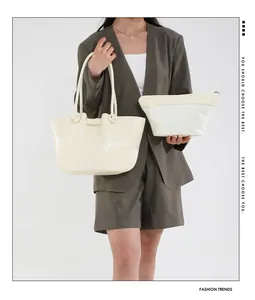 Dettaglio della borsa tote crema con manico a nodo e custodia con cerniera