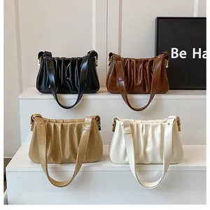 Detailed view of ruched cloud bags in four colors with glossy finish and long straps