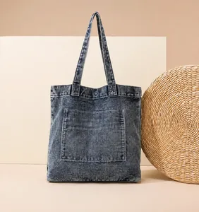 Makrodetail der gewaschenen Denim-Stoffstruktur und der großen Tasche am Retro-Shopper