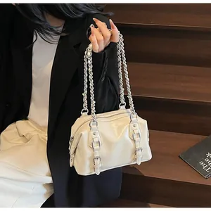 Detail of minimalist cream PU leather handbag with silver chain and metal buckle accents