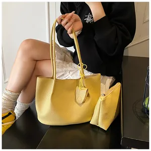 Close-up of vibrant yellow tote bag set including a small pouch with leaf pendant
