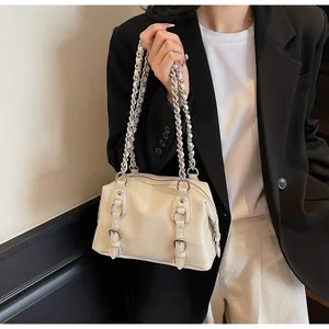 Detail of cream PU leather handbag featuring silver chain straps and metallic eyelets