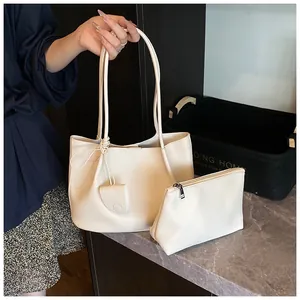 Close-up of beige lychee texture leather tote bag with a matching zipper pouch set