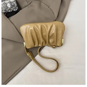 Detailed macro view of soft pleated PU leather texture and metal strap buckle on cloud bag
