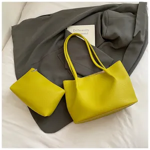 Detail of lemon yellow lychee texture tote bag and pouch set on a grey blazer background