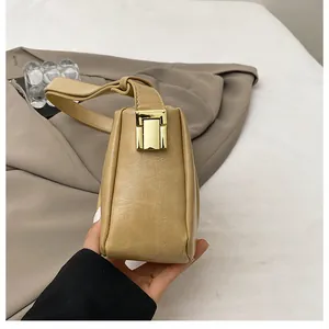 Detail of khaki leather shoulder bag with vintage pleats and golden metal buckle