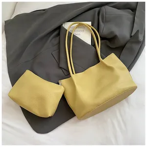 Detail of yellow tote bag with matching pouch on grey blazer showing pebbled texture