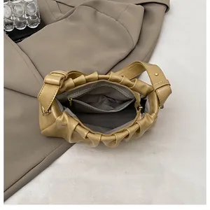 Internal view of khaki pleated cloud bag showing zipper pocket and soft lining detail