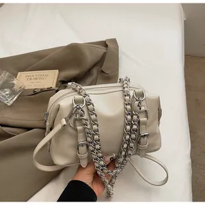 Detail of cream Boston handbag with dual silver metal chains and decorative buckles