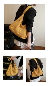 Detailed close-up of yellow crochet tote bag with multi-colored pearls and wide shoulder strap