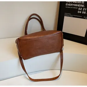 Detail showing high capacity base of brown PU leather tote bag with pebble texture
