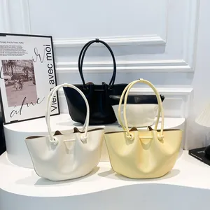 Grande borsa tote minimalista in pelle crema, giallo e nero con manici annodati