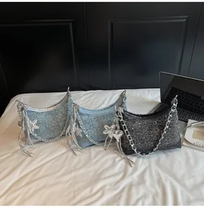 Detailed view of crescent denim shoulder bags with metal chain straps and star charms