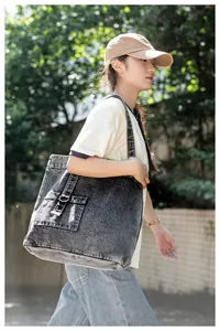 Detailansicht der grauen gewaschenen Denim-Tasche mit Vintage-Metallringschnalle an der Tasche