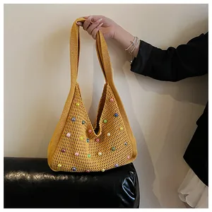 Detailed close-up of yellow knit tote bag featuring colorful faux pearl embellishments
