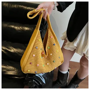 Detailed knit texture of mustard yellow tote bag with colorful faux pearls and crochet design
