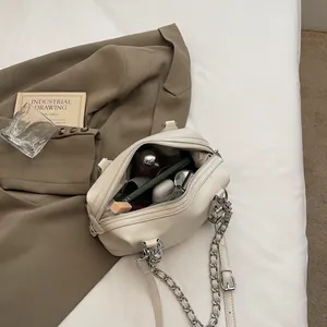 Chic off-white crossbody bowling bag with silver chain strap and everyday essentials
