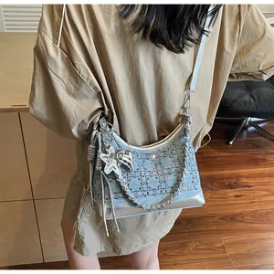 Detailed view of Y2K denim hobo bag featuring silver trim and metal star heart charms