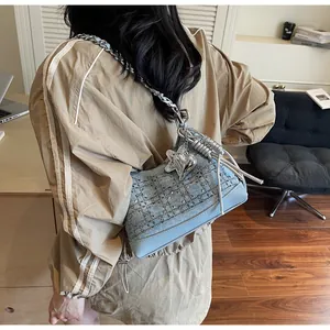 Detailed view of denim crossbody bag with sparkling rhinestones and silver chain strap