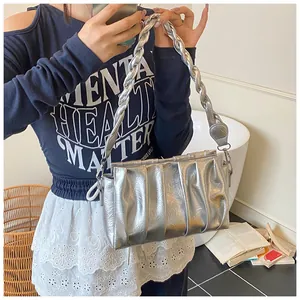Detailed view of silver metallic pleated cloud bag with a chunky braided shoulder strap