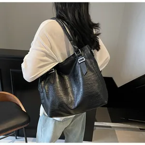 Close-up of a black leather tote bag with lychee texture and silver metal hardware details