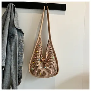 Detail of woven boho tote bag with colorful pearls and wide shoulder strap