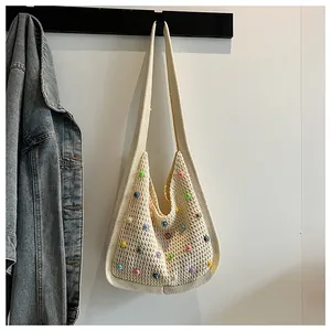 Detail of hand-woven off-white tote bag featuring vibrant colorful beads and soft textures