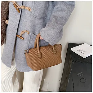 Détail du sac cabas en PU marron avec texture tressée et poignée ronde rigide