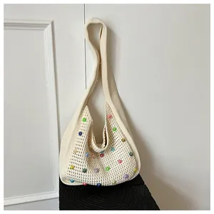 Close-up of crochet knit tote bag with colorful faux pearls and hollow-out texture