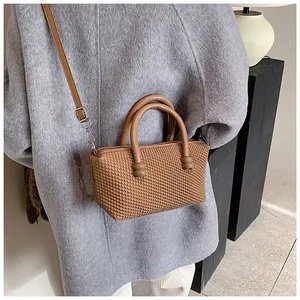 Détail du sac à bandoulière marron texturé avec anses rondes et accents sphériques