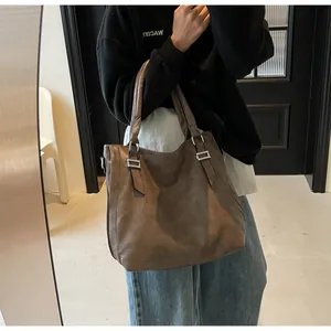 Mirror selfie showing the large vintage brown leather tote bag for daily commute