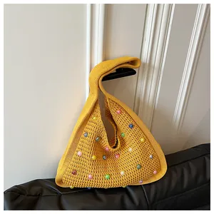 Detailed close-up of yellow knitted tote bag featuring colorful faux pearl embellishments