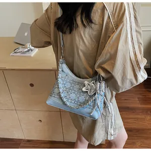 Detail of light blue denim tote with rhinestone diamond lattice and silver chain strap