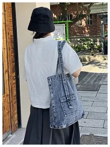 Detail der dunkelblauen Denim-Einkaufstasche mit Tasche und D-Ring am Outdoor-Modell