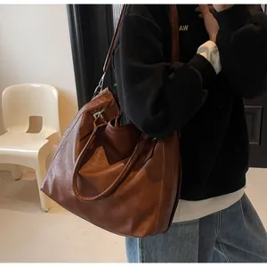 Detail of vintage dark brown tote bag showing textured faux leather and metal buckle detail