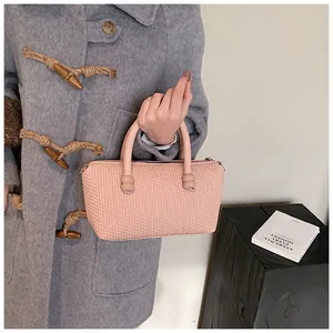 Détail de la texture tressée rose et de la finition en cuir premium du sac à main chic