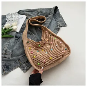 Detailed view of khaki woven tote bag with colorful pearl beads on casual shoulder strap