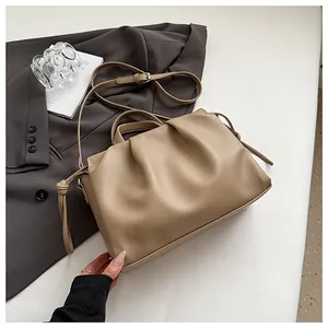 Macro shot of pleated beige crossbody bag showing lychee grain leather and drawstring detail