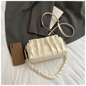 Detailed view of pleated crossbody bag capacity showing phone fitting inside the cloud pouch