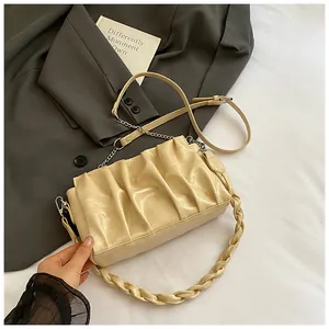 Detail of beige ruched cloud bag featuring pleated PU leather and dual strap system