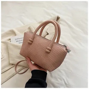Détail du sac à main rose à texture tissée avec poignée robuste et fermeture éclair