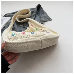 Close-up of cream woven tote bag showing colorful bead details and crochet knit texture