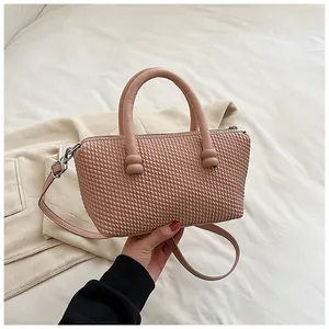 Détail du sac à main rose nude avec texture tissée 3D et doubles poignées arrondies