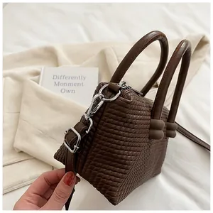 Vue détaillée du sac cabas marron à texture tissée et boucles métalliques argentées
