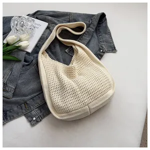 Detail of cream woven tote bag showing crochet knit texture on denim background